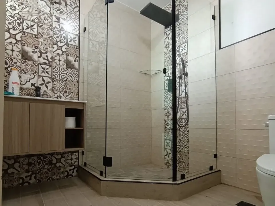 Cabina de ducha en ángulo con tres paños de vidrio templado, puerta batiente y herrajes negros