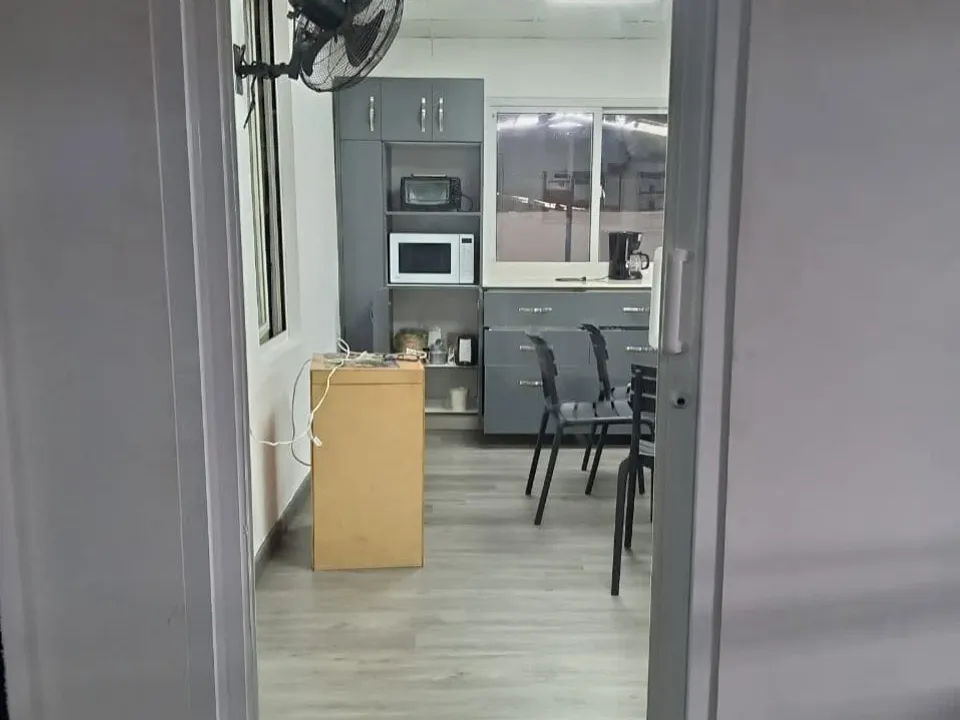 Comedor de oficina cerrado con una puerta de vidrio y marco de aluminio blanco
